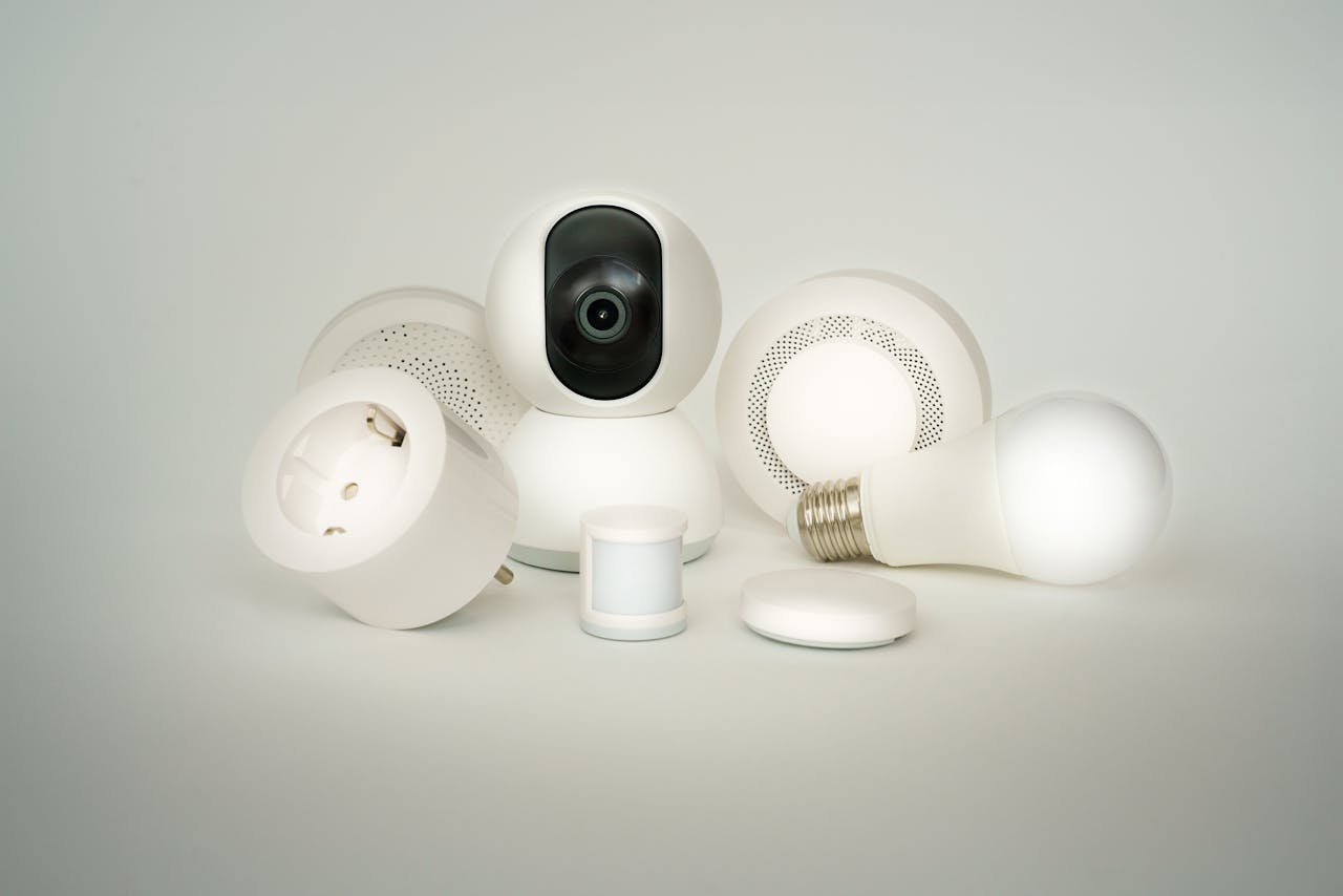 A collection of smart home devices including bulbs, sockets, and cameras on a white backdrop.
